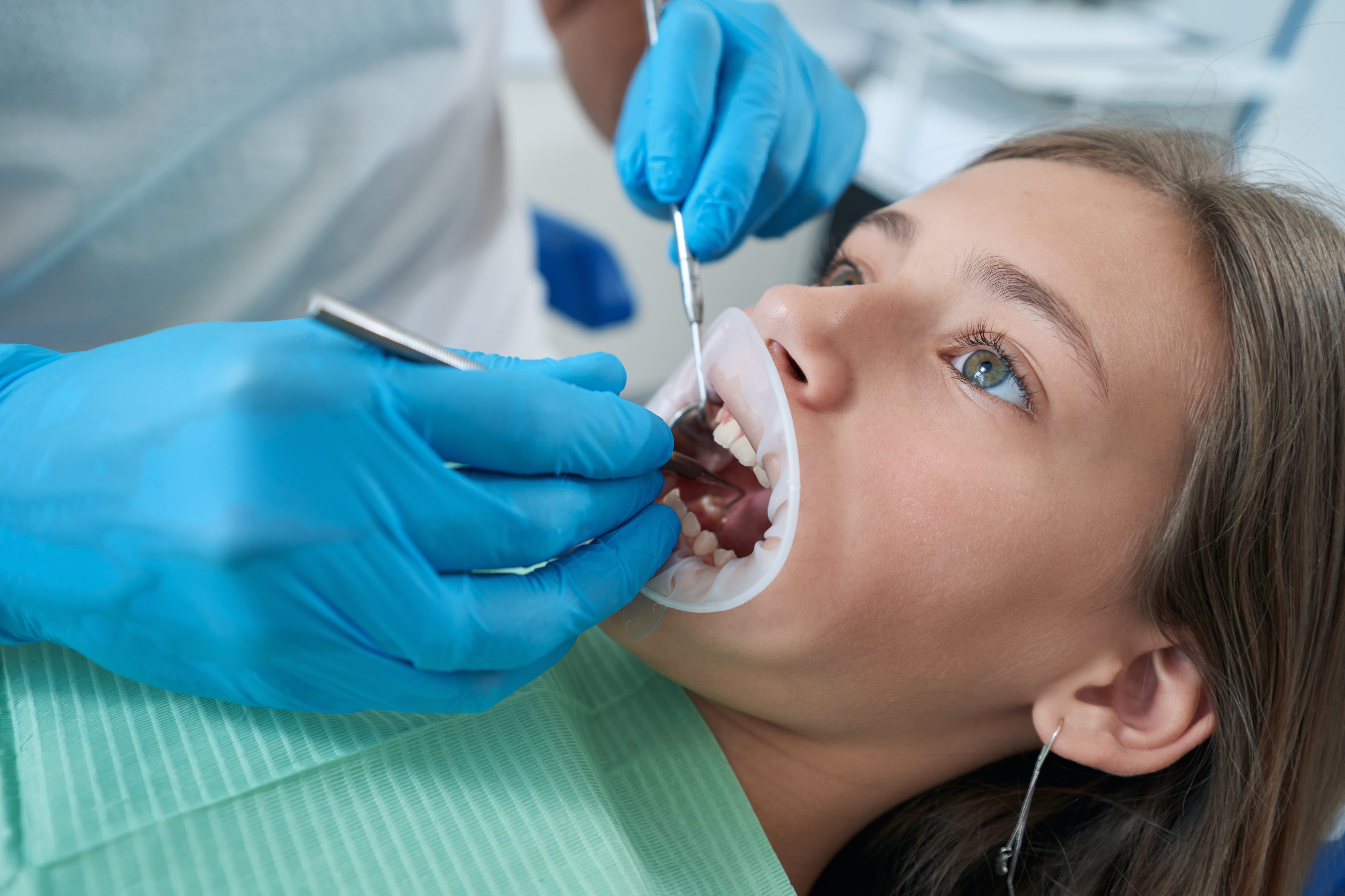 pedodontist-examining-teeth-and-gums-of-